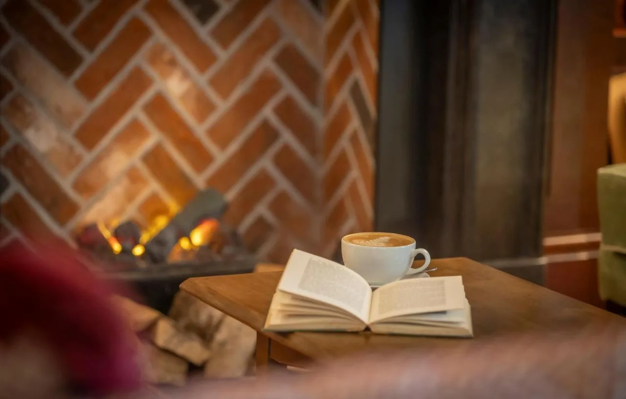 Coffee and a book on a table in the hotel library