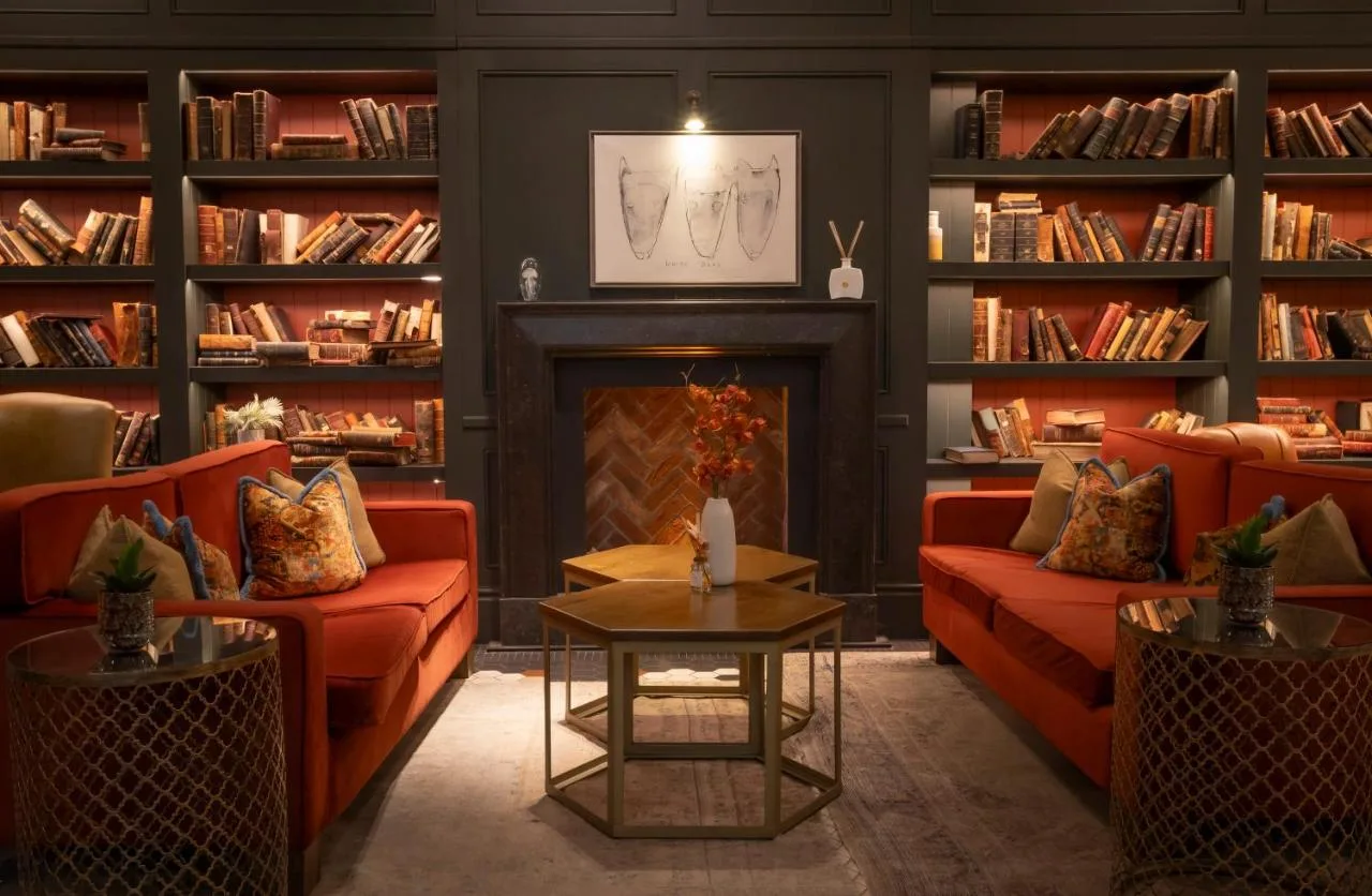 Library with red couches and fireplace above the lobby